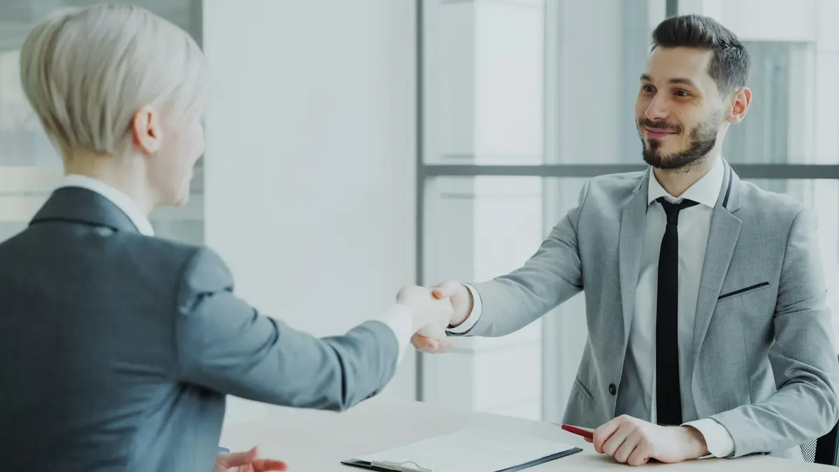 Aperto de mão entre corretor e cliente em um escritório